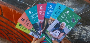 Image of hands holding seven colourful ward brochures